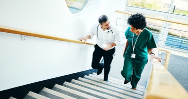 A doctor and nurse walking up stairs - HealthStream Leadership Development